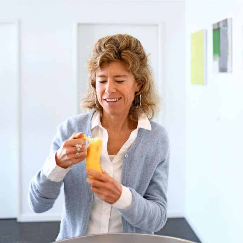 Caroline Linda Bucher hält eine Banane in der Hand und schält diese.