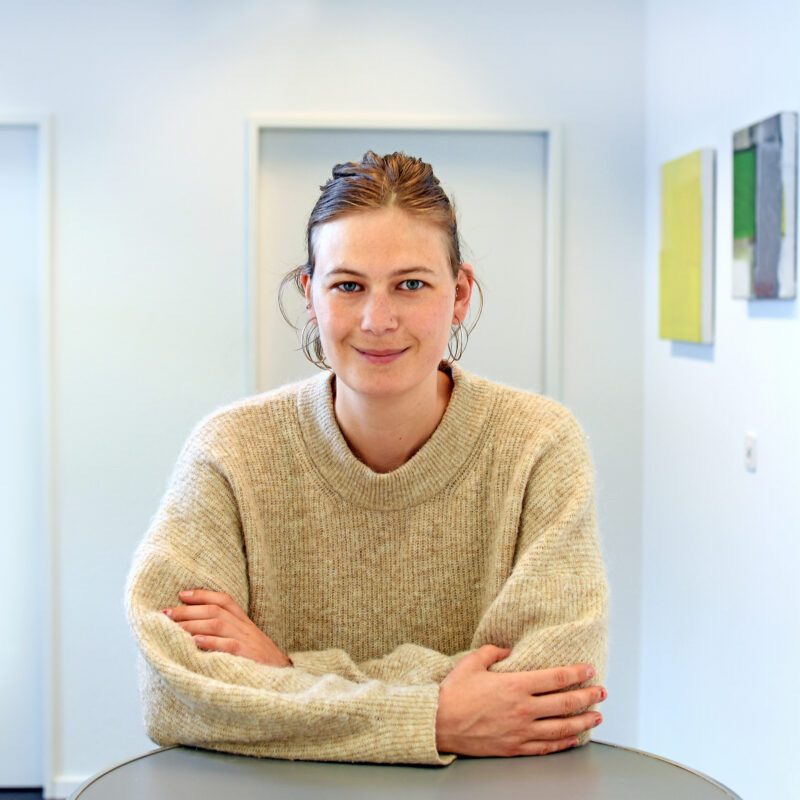 Michèle Flury steht an einem Tisch und lächelt in die Kamera