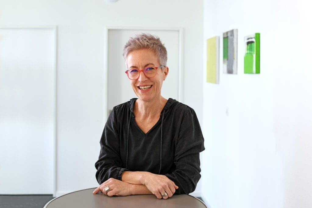 Sabina Cannarozzo stands at a table and smiles at the camera.