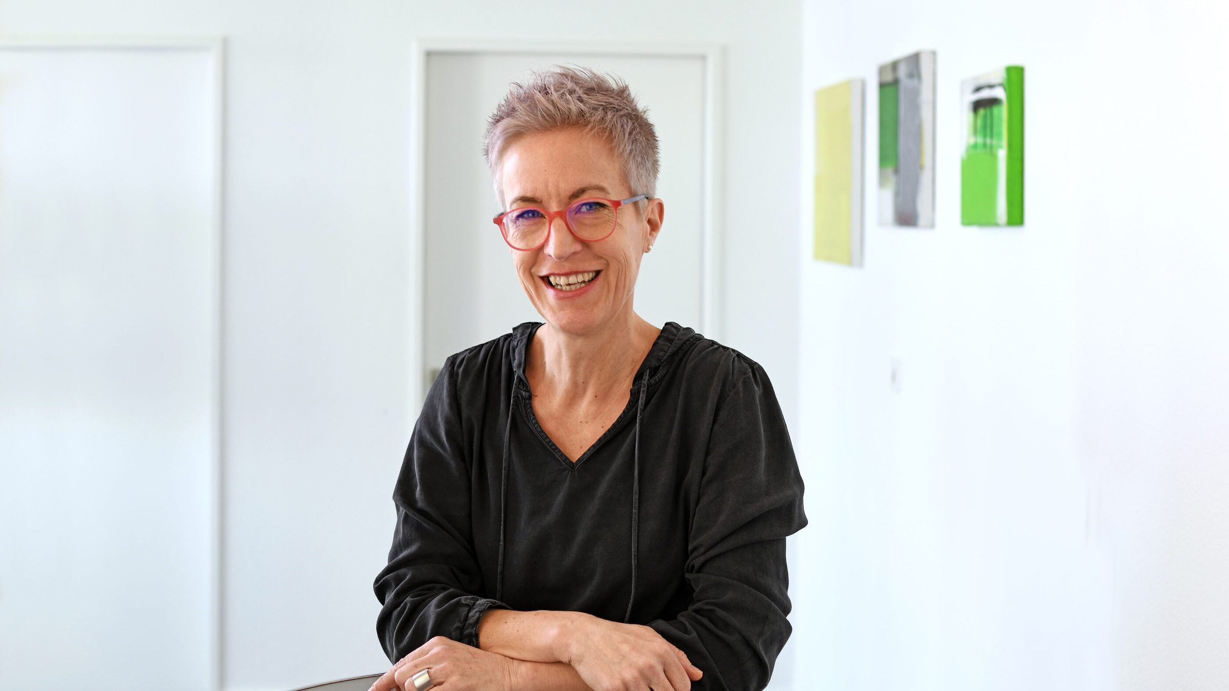 Sabina Cannarozzo steht an einem Tisch und lächelt in die Kamera.